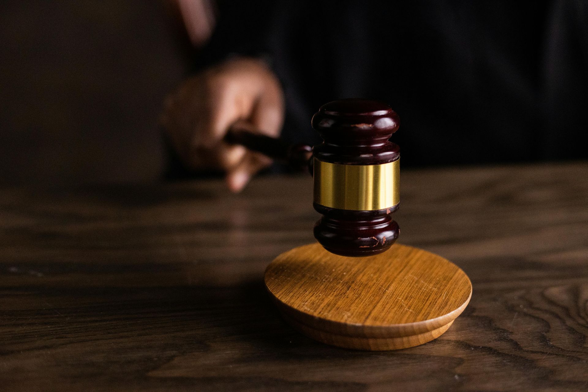 A judge's wooden gavel resting on its sound block
